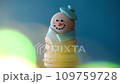 Snowman dessert macaron decorated with hat and scarf against colorful background and flashing bokeh on foreground. Merry Christmas and Happy New Year festive concept 109759728