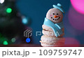 Snowman dessert macaron decorated with hat and scarf against Christmas tree, colorful lights and bokeh background. Camera moves away from the object. Merry Christmas and Happy New Year festive concept 109759747