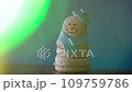 Snowman dessert macaron decorated with hat and scarf against colorful background and flashing bokeh on foreground. Merry Christmas and Happy New Year festive concept 109759786