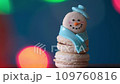 Snowman dessert macaron decorated with hat and scarf against colorful lights and bokeh background. Camera moves away from the object. Merry Christmas and Happy New Year festive concept 109760816