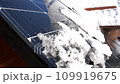 Snow Melting on PV Solar Panels Located on Private House Roof on Sunny Day 109919675
