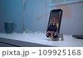 A young man shoots a video on a smartphone while reading text from a teleprompter on a screen 109925168