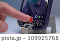 A young man shoots a video on a smartphone while reading text from a teleprompter on a screen 109925768