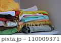 A woman puts clothes in a wardrobe at home. Neatly folded things on the closet shelf. Maintaining order at home. Daily routine. Housewife and housekeeping hacks. 110009371