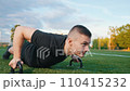 Young man exercising outdoors, does push-ups on the push-up platform at stadium 110415232