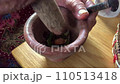 old grandmother's hand is pounding spices and betel nuts for traditional Asian chewing. 110513418