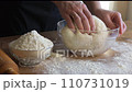 Mixing dough for baking. A woman's hand kneading dough. 110731019