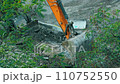 Excavator transferring a ground with a heavy bucket. Excavator at work. Tractor with a bucket on a construction site. A construction machine is making a road. Excavator bucket breaks the road asphalt 110752550