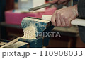 Video. Carpenter sharpens wooden product with file on workbench and sawdust flies. Close-up. Hands 110908033