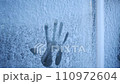 A handprint on a frozen window pane. Natural winter background. 110972604