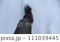 雪道を歩く人の足元 111039445