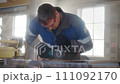 Slow motion video. Overall plan. Working man in overalls works with angle grinder in workshop 111092170