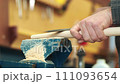 Close-up real-time video. Worker in carpentry workshop sharpens wooden stick with file. Carpenter 111093654