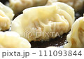 Close-up of cooking fried japanese dumplings or gyoza in frying pan. 111093844