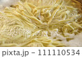 Close-up of homemade pasta in boiling hot water. Metal spoon mixes the pasta in boiling water. 4K 111110534