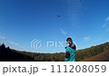 Young girl steering bird-like kite in nature 4 111208059