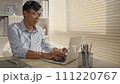 Man using laptop to work on table in office, Press the keyboard on the laptop, Remote work. 111220767