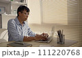 Man using laptop to work on table in office, Press the keyboard on the laptop, Remote work. 111220768