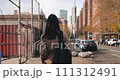 Attractive woman strolling in the urban and vibrant streets of New York on bright day 111312491