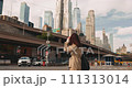 Happy free woman walking in dynamic and thriving New York City streets on bright day 111313014