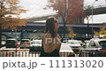Happy attractive female walking in beautiful autumn sun with the iconic Brooklyn Bridge in the background. 111313020