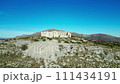 Stunning rock formation amidst field with sky, mountain, and natural landscape. 111434191