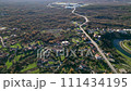 An aerial view of a residential area surrounded by trees and a river 111434195