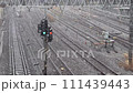 大雪の日の都心の線路と鉄道信号機 111439443