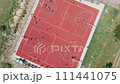 Aerial top down view of young athletes playing basketball on an outdoor public basketball court in summer. Aerial view of young athletes playing streetball on an outdoor sports ground. 111441075
