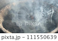 Hot burning charcoal briquettes in a grill emitting smoke and flames, preparing for outdoor cooking. 111550639