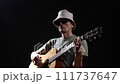 Musician playing acoustic guitar on black background 111737647