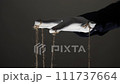 Manipulator hands in white gloves with ropes on fingers 111737664