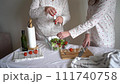 teenage girl and mother in pajamas prepares a fresh salad of greens and tomatoes 111740758