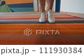 Close-up of white sneakers on multicolored rug walking in a hotel corridor - steadicam shot 111930384