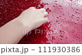 Woman hand tracing a heart shape on wet car hood 111930386