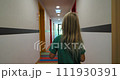 Rear view of girl walking in a bright hallway in a hotel - steadicam shot 111930391