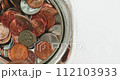 Closeup looping clip coins falling into glass jar with audio with white copy space. concepts of saving, thriftiness, business, finance, buting a home, and economics. High quality 4k footage 112103933