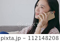 一位年輕女子在客廳打電話 112148208