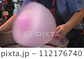 Closeup view of a person making the cotton candy for the customer. 112176740