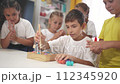child boy group playing fishing. a group of children collect building blocks in a kindergarten indoors. children in kindergarten play with toys. happy family lifestyle kid dream concept 112345920