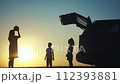 family traveling by car. family watching the sunset silhouette next to the car in the park. family playing ball. people lifestyle in the park. family car camping resting in nature 112393881