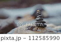 Close up of balanced stones stacked on the big rock near the river. Slow motion. 112585990