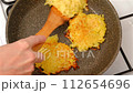 Top view of flipping potato pancakes in frying pan with spatula 112654696