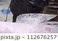 Closeup of ice sculptor grinding shaping ice detail 112676257