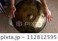 Hang drum played by young female overhead shot. Female hands practicing native music traditional drumming instrument. High quality 4K footage. 112812595
