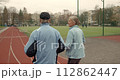 Couple old men running marathon stadium arena. Grandparent jog together. Romantic elderly smiling people sport training. Granny and Grandpa workout. Love athletes. Active senior lifestyle. Health care 112862447