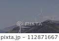 A group of windmills lined up in the mountains 112871667