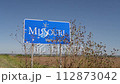 Missouri Welcomes You - a roadside sign at a state border with Nebraska, fall scenery with dry sunflowers moved by wind 112873042