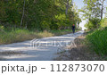 senior male cyclist on a gravel bike riding Steamboat Trace Trail in Nebraska near Peru, the trail is converted from old railroad running along the Missouri River  112873070