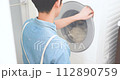 A man in an apron doing laundry 112890759